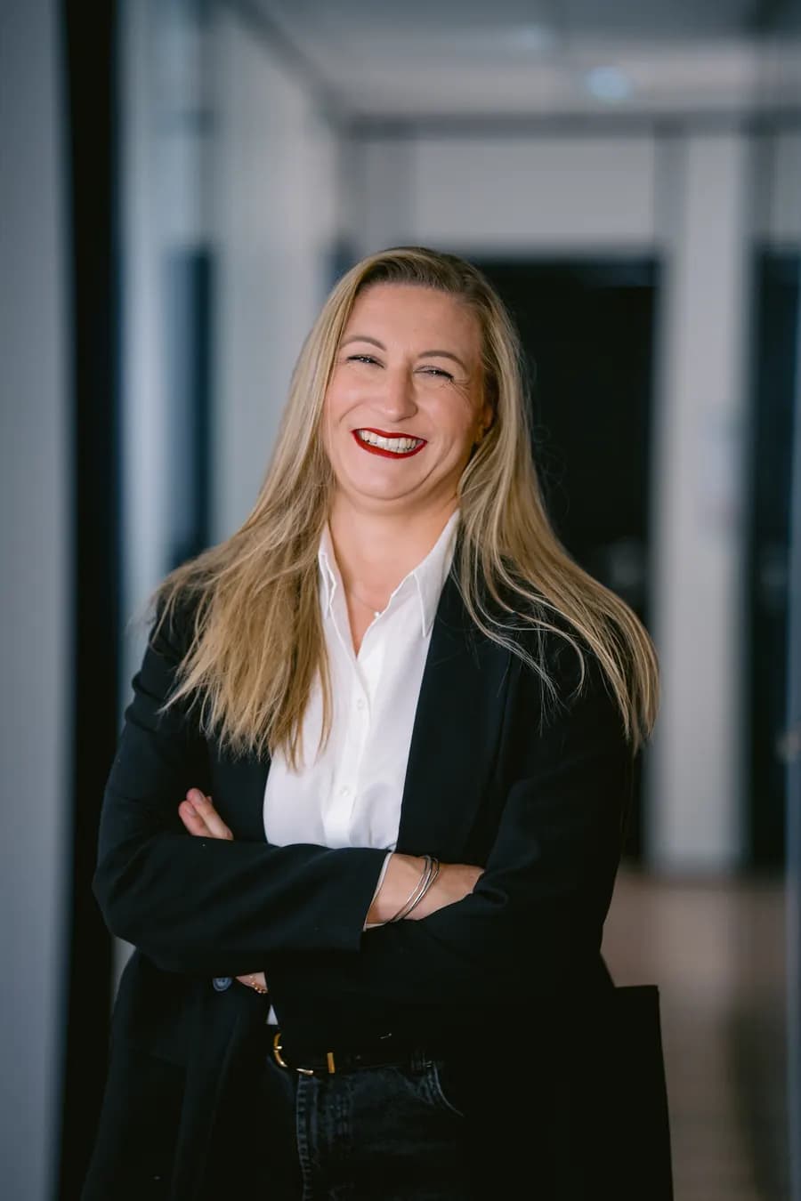 Portrait souriant d’une avocate de Praeteom, blazer noir et chemise blanche.